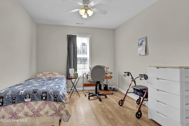 bedroom with baseboards, ceiling fan, visible vents, and wood finished floors
