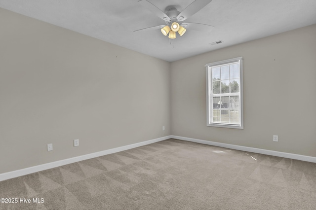 carpeted spare room featuring baseboards, a ceiling fan, and visible vents
