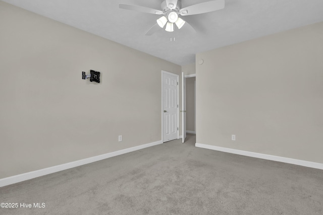 carpeted empty room featuring baseboards and a ceiling fan