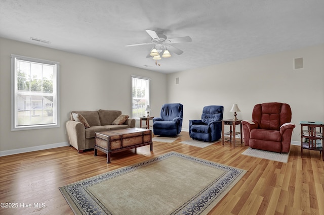 living area featuring visible vents, plenty of natural light, and wood finished floors