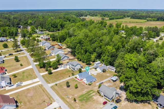 drone / aerial view featuring a residential view and a wooded view