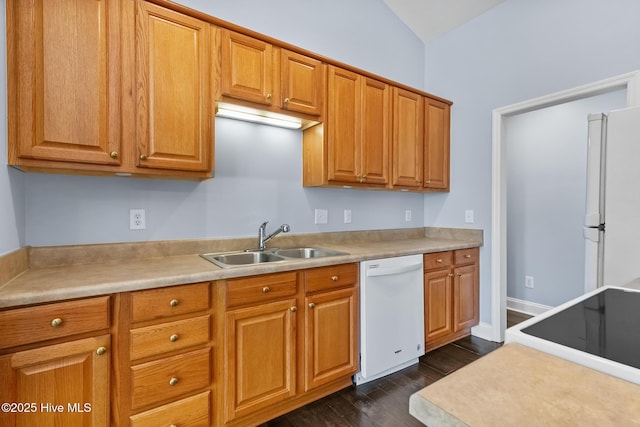 kitchen with brown cabinets, a sink, white appliances, light countertops, and dark wood-type flooring