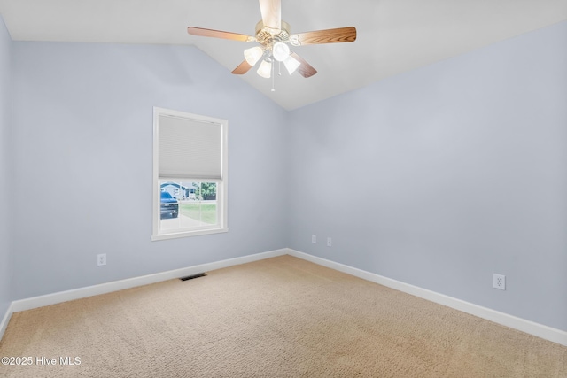carpeted spare room featuring a ceiling fan, baseboards, visible vents, and lofted ceiling