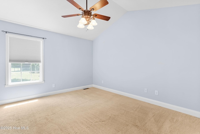 empty room featuring carpet floors, baseboards, ceiling fan, and lofted ceiling