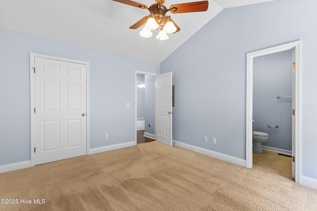 unfurnished bedroom featuring carpet floors, baseboards, ensuite bathroom, ceiling fan, and vaulted ceiling