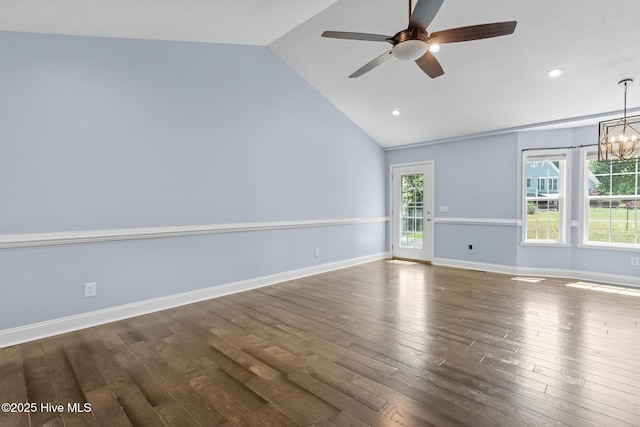 empty room featuring wood finished floors, lofted ceiling, and ceiling fan with notable chandelier