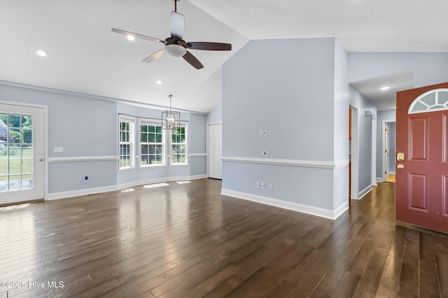 unfurnished living room featuring ceiling fan with notable chandelier, dark wood-style flooring, and a wealth of natural light