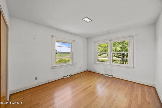 empty room with baseboards, visible vents, and light wood-style flooring