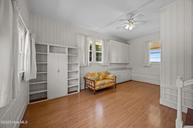 living area featuring light wood-type flooring, a ceiling fan, and plenty of natural light