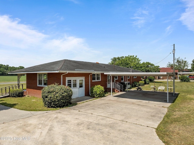 ranch-style home with a carport, driveway, a front lawn, and brick siding