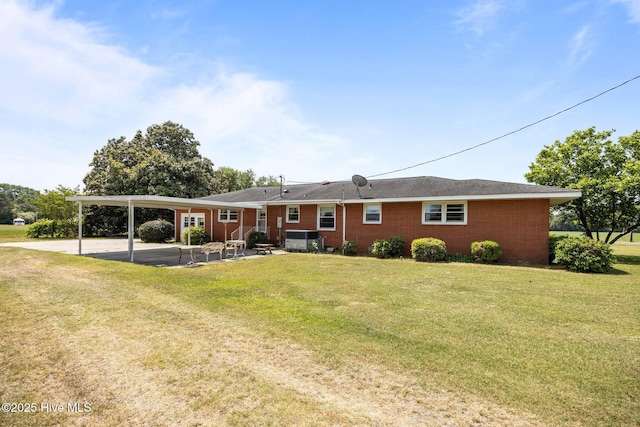 rear view of property with a yard and an attached carport