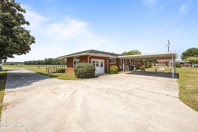 ranch-style house with brick siding, driveway, and a front yard