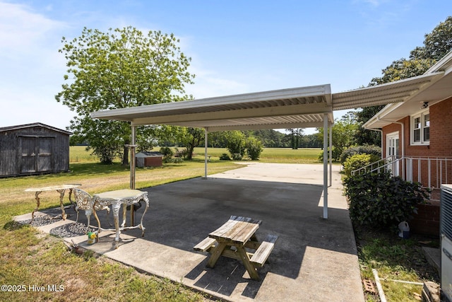 view of patio featuring a shed, an outbuilding, driveway, and a carport