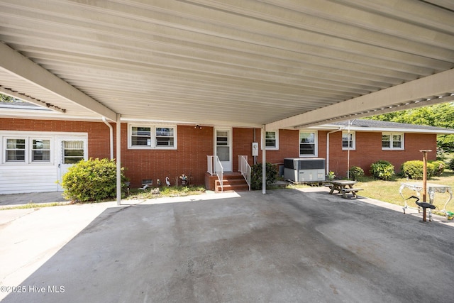 exterior space featuring brick siding, cooling unit, and a jacuzzi