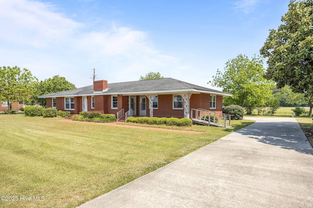 single story home featuring a porch, a chimney, a front yard, and concrete driveway