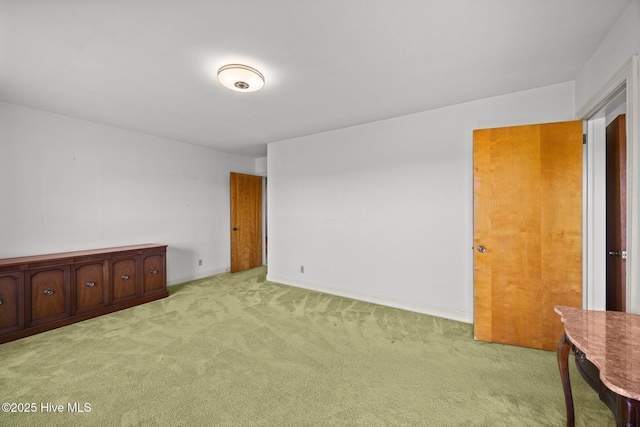 spare room featuring baseboards and light carpet