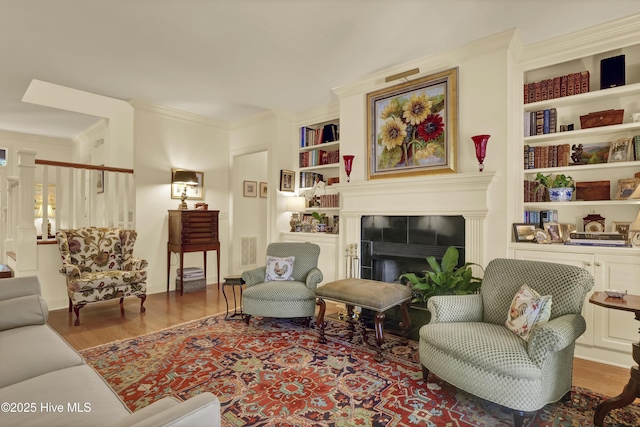 7102 Saybrook Dr, Wilmington, NC 28405 - living room featuring ornamental molding, built in shelves, wood finished floors, a fireplace, and baseboards