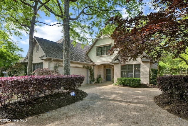 7102 Saybrook Dr, Wilmington, NC 28405 - view of front facade featuring an attached garage, concrete driveway, brick siding, and a shingled roof