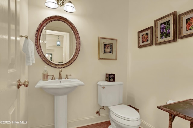 7102 Saybrook Dr, Wilmington, NC 28405 - half bathroom with baseboards, toilet, and a chandelier