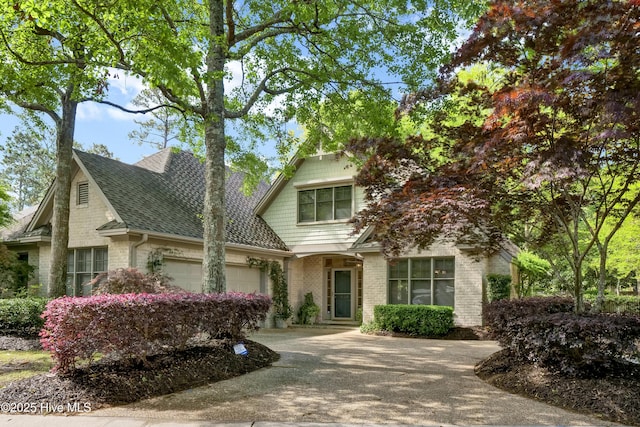 7102 Saybrook Dr, Wilmington, NC 28405 - view of front of house with an attached garage, concrete driveway, a shingled roof, and brick siding