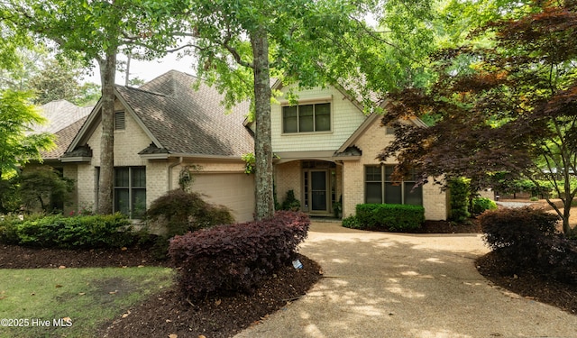 7102 Saybrook Dr, Wilmington, NC 28405 - view of front of home featuring brick siding, an attached garage, driveway, and roof with shingles