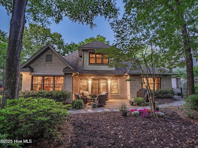 7102 Saybrook Dr, Wilmington, NC 28405 - rear view of property featuring a shingled roof, outdoor lounge area, brick siding, a patio area, and fence