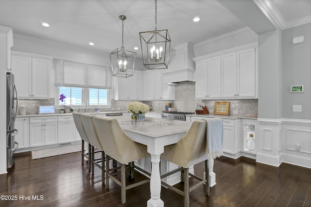 6221 Chalfont Cir, Wilmington, NC 28405 - kitchen featuring a breakfast bar, light stone counters, white cabinetry, dark wood-type flooring, and a kitchen island