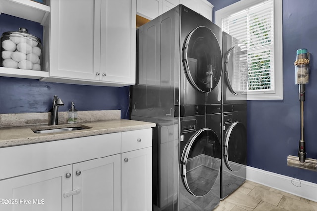 6221 Chalfont Cir, Wilmington, NC 28405 - washroom with baseboards, a sink, cabinet space, and stacked washing maching and dryer