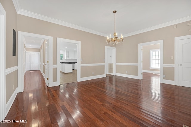 114 N Atlantic Ave, Southport, NC 28461 - spare room with a chandelier, healthy amount of natural light, crown molding, dark wood-style floors, and baseboards
