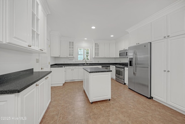 114 N Atlantic Ave, Southport, NC 28461 - kitchen featuring stainless steel appliances, a sink, white cabinets, a center island, and glass insert cabinets