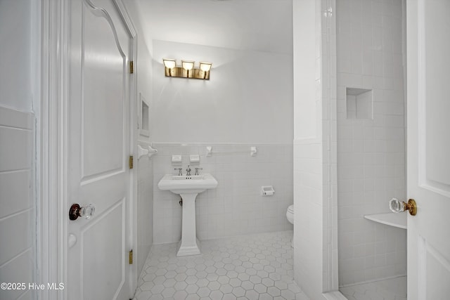 114 N Atlantic Ave, Southport, NC 28461 - full bathroom featuring toilet, tile patterned floors, wainscoting, and tile walls
