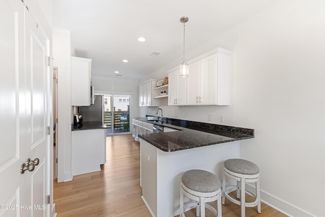 kitchen with light wood-type flooring, a sink, open shelves, and white cabinets