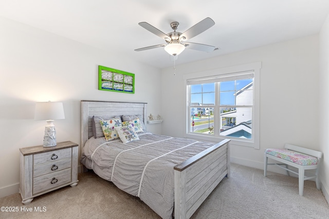 bedroom featuring baseboards, light colored carpet, and ceiling fan