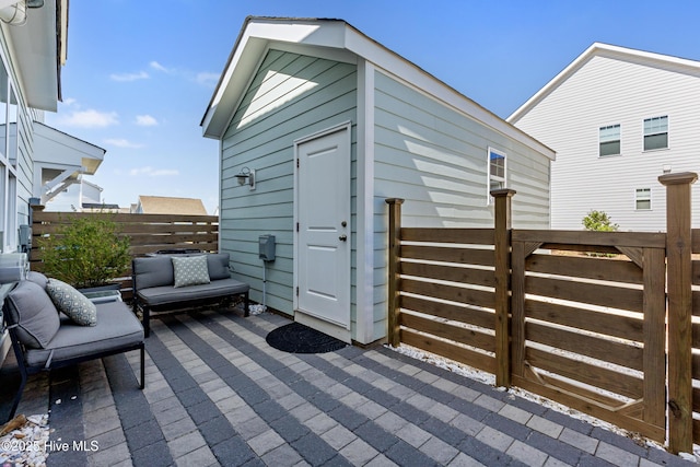 view of outbuilding featuring fence and an outdoor structure