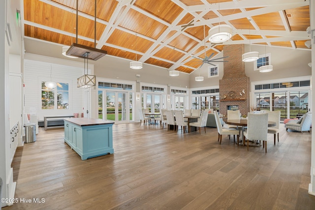 dining space with a ceiling fan, wood ceiling, hardwood / wood-style floors, and high vaulted ceiling