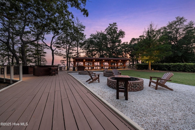 exterior space with a lawn, a fire pit, and a deck