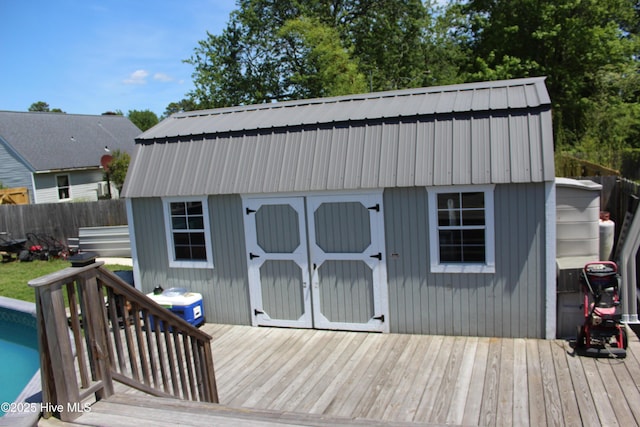 wooden deck with fence, an outbuilding, and a storage unit