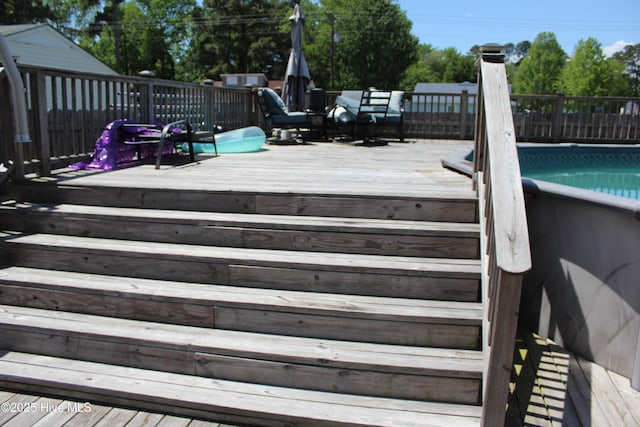 wooden terrace featuring a fenced in pool