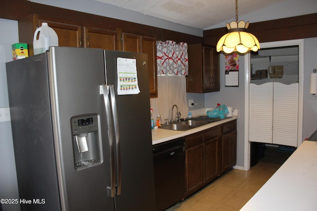 kitchen featuring a sink, stainless steel fridge with ice dispenser, light countertops, black dishwasher, and pendant lighting
