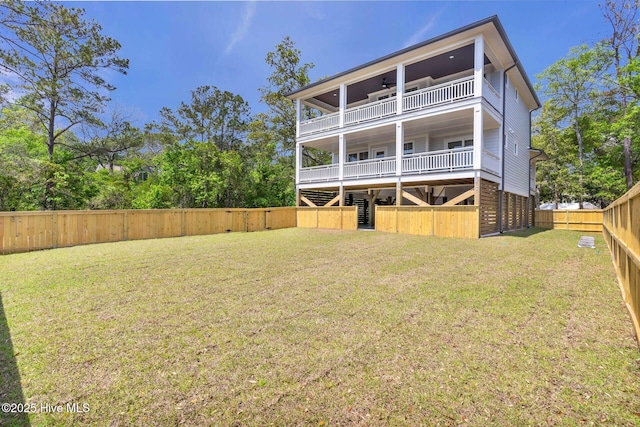 110 SW 26th St, Oak Island, NC 28465 - rear view of house with a ceiling fan, a lawn, stairway, a balcony, and a fenced backyard