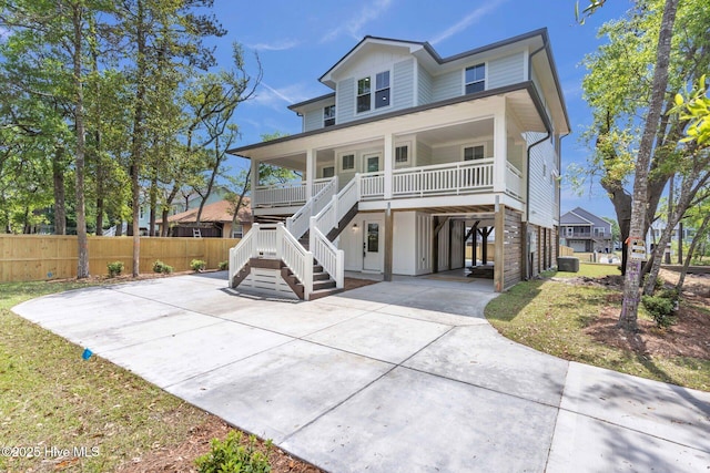 110 SW 26th St, Oak Island, NC 28465 - beach home with fence, a porch, stairway, concrete driveway, and a carport