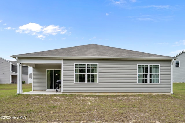 rear view of property with a patio and a lawn