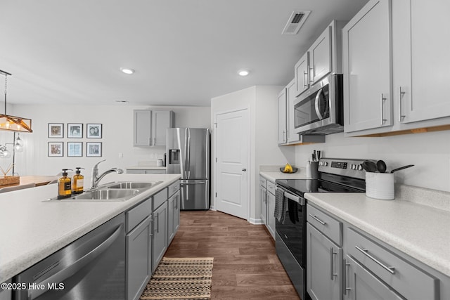 kitchen featuring appliances with stainless steel finishes, light countertops, and a sink