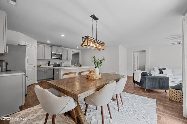 dining space featuring a notable chandelier, recessed lighting, visible vents, and wood finished floors