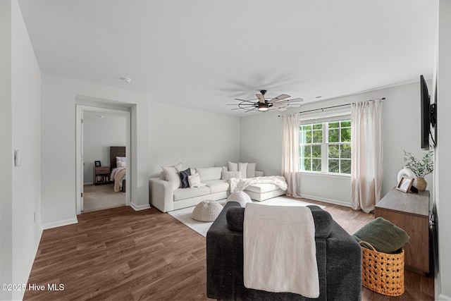 living room featuring ceiling fan, wood finished floors, and baseboards
