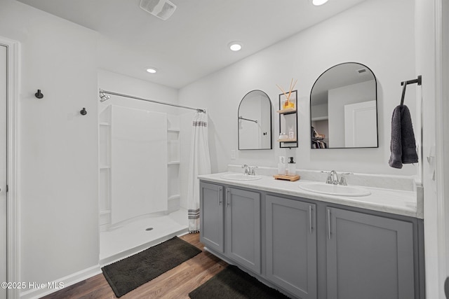 bathroom featuring visible vents, wood finished floors, curtained shower, and a sink