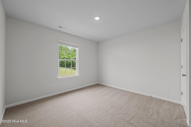 carpeted empty room featuring visible vents and baseboards
