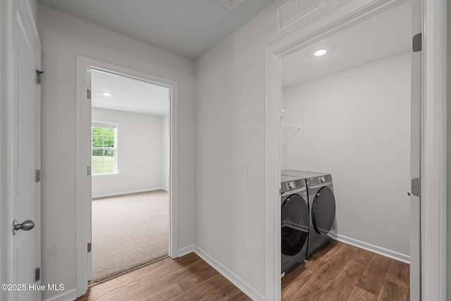 laundry area with visible vents, baseboards, washer and clothes dryer, wood finished floors, and laundry area
