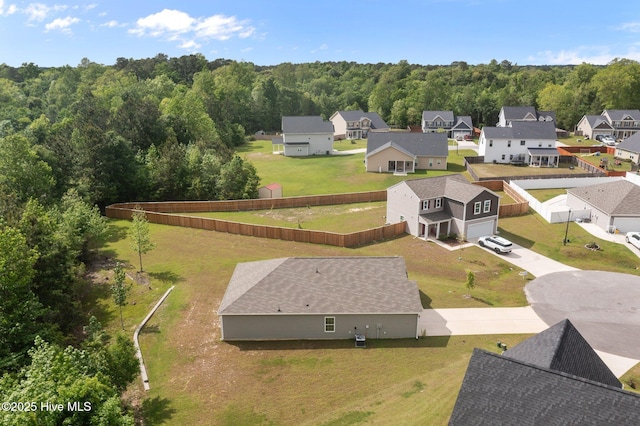 drone / aerial view featuring a residential view and a forest view