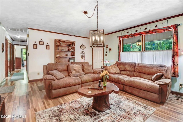 720 Swains Mill Rd, Harrellsville, NC 27942 - living room featuring ornamental molding, light wood finished floors, baseboards, attic access, and a chandelier